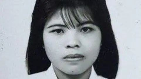 North Yorkshire Police A black and white image of woman with shoulder-length black hair. She is wearing a white dress with a heart brooch. 