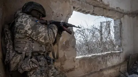 Image shows Ukrainian soldier during training