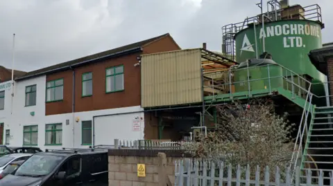 Google A two storey white brick building with a large green storage tank on the right hand side of the property emblazoned with the words Anochrome Ltd.