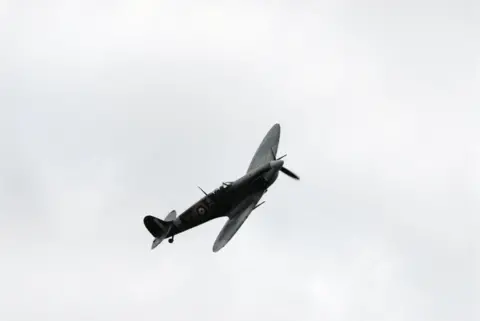 A traditional fly past of a WWII Spitfire, above the annual Proms concert at Stonor Park, Henley-upon-Thames, Oxfordshire.