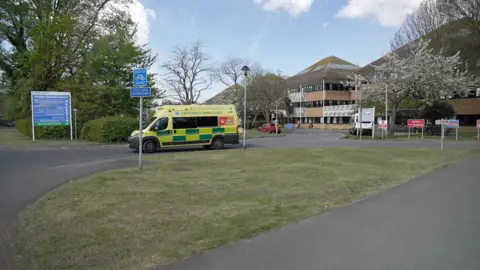 An outside shot of Weston General Hospital. An ambulance can be seen driving out of the hospital.