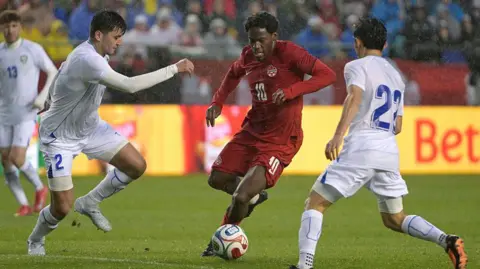 Soccrates via Getty Images Abdukodir Khusanov of Uzbekistan, Jonathan David of Canada and Abbosbek Fayzullaev of Uzbekistan are pictured in a recent friendly match