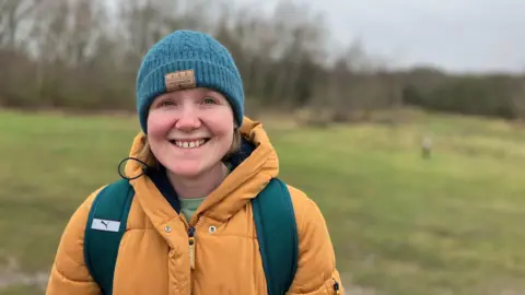 Ruth Gentle, stood in front of an area of grass with trees in the background