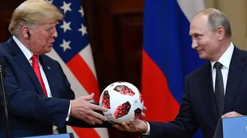 Vladimir Putin hands a football to Donald Trump during a meeting in Helsinki, Finland, in July 2018