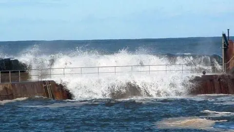 Staithes Coastguard A picture of the pier on Staithes Harbour which shows waves crashing over the side of the railings