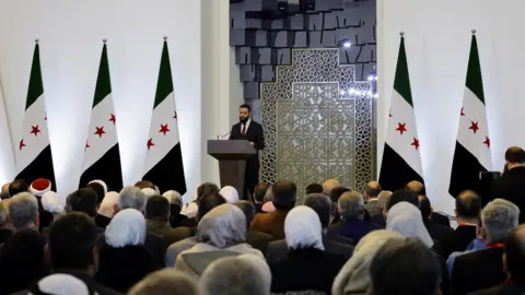 Reuters Syrian temporary President Ahmed al-Sharaa addresses a national conference on Damascus dialogue in Syria (February 25, 2025)