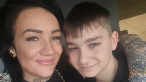 Supplied A selfie-style image of Jade Kirkpatrick and her son Rocco. Jade has her heavily tattooed arm around her son's shoulder. They are both smiling and looking into the camera.