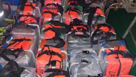 Border Force Bundles of bags containing cocaine are stacked next to each other on the floor of a vessel