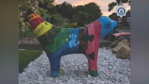 A side view of the multicoloured painted Superlambanana sculpture