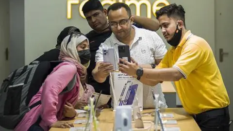 Getty Images Customers interact with the staff of Realme showroom store at Karol Bagh in New Delhi, India, on Tuesday, May 31, 2022