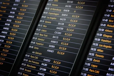 Departure board at Heathrow airport showing flights to New York, LA and others