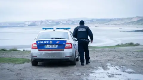 PA Media File photo of a French Police officer looking out over a beach in France