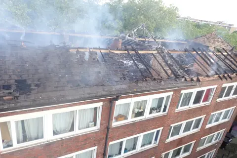 LFB Smoke rises from roof of Dalston Lane flats