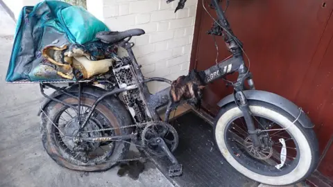 LFB Charred remains of e-bike fire with a food delivery bag 