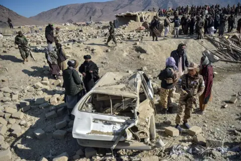 AFP Taliban security personnel inspect a damaged car two days after air strikes by Pakistan in the Barmal district of eastern Paktika province on December 26, 2024. Pakistan air strikes in an eastern border region of Afghanistan killed 46 civilians, the Taliban government said on December 25, whilst a Pakistan security official said the bombardment had targeted "terrorist hideouts".