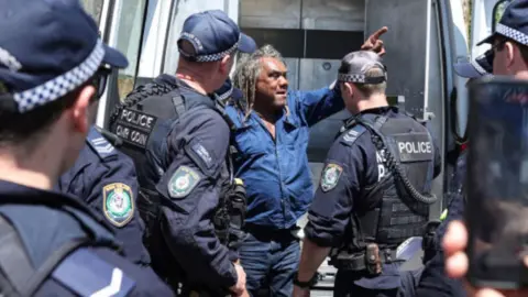 Indigenous protester arrested by police in Sydney.