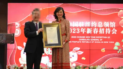 US Department of Justice Linda Sun poses for a photo with a Chinese official