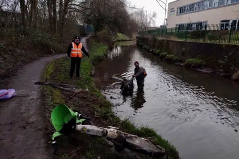 Little Litter Pickers of Nottingham Ethan Radford standing in the River Leen with a Lime bike in the foreground