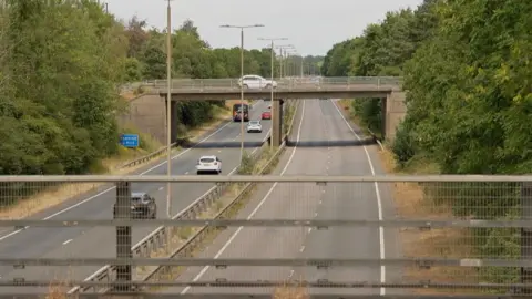 A view of the A38 carriageway from a bridge.