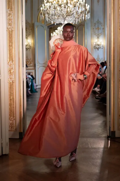 Rooful Ali A model wearing a large pink dress walks the runway during Paris Modest Fashion Week 2026 