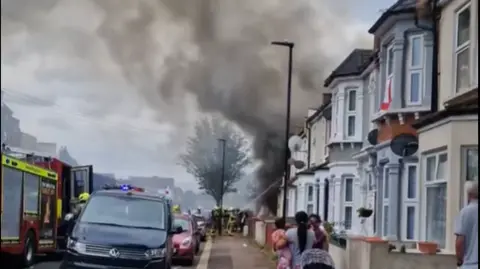 TERRY ROBERT Firefighters tackling fire the fatal house fire in East Ham