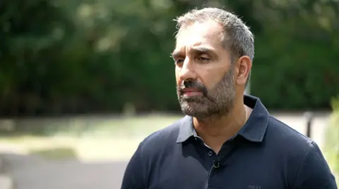 Man in black shirt with beard and grey hair