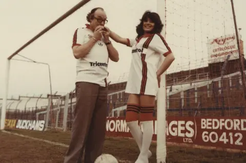 Hatters Heritage Eric Morecambe with model Jackie Jones wearing the club's 1980 kit at Kenilworth Road
