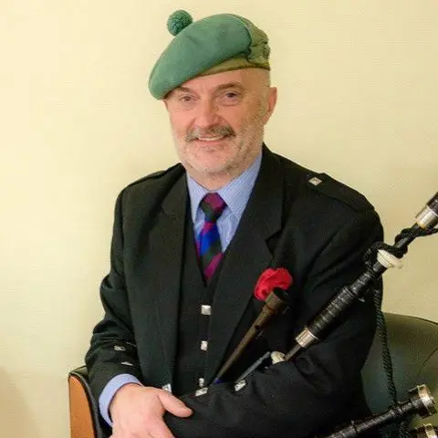 Robert Wallace, Piping Press Robert Wallace sits with his bagpipes