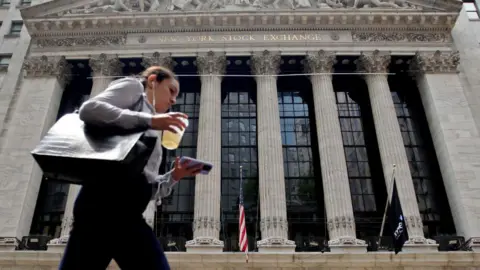 Getty Images A woman walks near the New York Stock Exchange on July 18, 2023 in New York City.