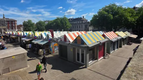 Paul Moseley/BBC Several of Norwich's market stalls which have brightly coloured, striped roofs.