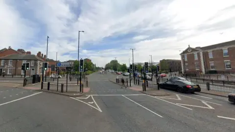 The junction between St Michael's Way and Green Terrace. The junctino contains traffic lights. A sign for The Bridges car park points to the left.