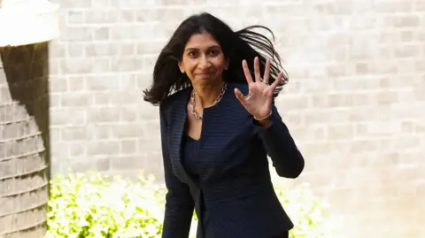 Reuters Suella Braverman walking in Downing Street waving to photographers