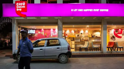 Getty Images A Hindustan Petroleum Corp. employee stands in the gas station forecourt in front of a Cafe Coffee Day store, operated by Amalgamated Bean Coffee Trading Co., in Jaipur, Rajasthan, India, on Monday, Oct. 13, 2014