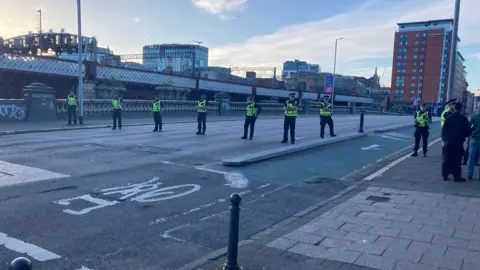 Police officers spread out across an empty bidge