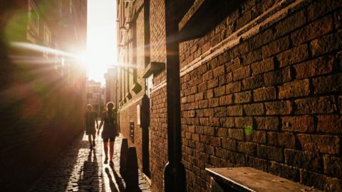 The sun sets over an alleyway in a residential area of the Stoke Newington district of London, UK, on Tuesday, Aug. 22, 2023.