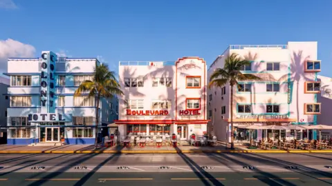 Getty Images A row of brightly coloured art deco hotels pictured against a clear blue sky with palm trees in front