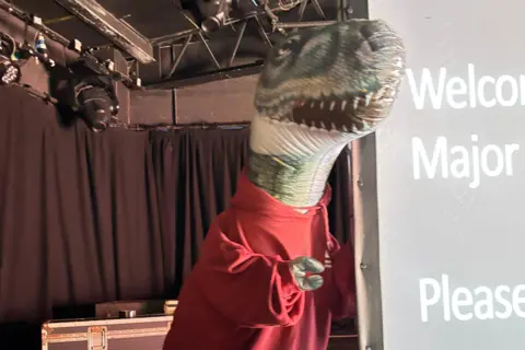 BU A blow up Godzilla in a red hoodie.