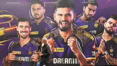 Getty Images People are passing next to the Kolkata Knight Riders team bus in Kolkata, India, on May 26, 2024. 