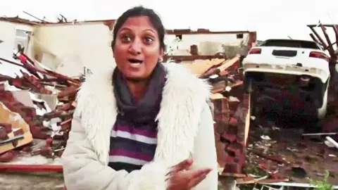 A woman showing her house destroyed by a storm in south africa