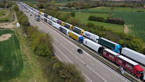 Getty Images An overhead view of cars passing freight lorries and HGVs (heavy goods vehicles) queued up on the M20 road near Ashford heading towards the port of Dover as Operation Brock is employed