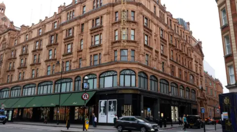 Reuters A general view of the Harrods department store in London. The building has the famous grand red bricks and green canopy draping over the pavements. A car can be seen driving past along Cromwell Road.