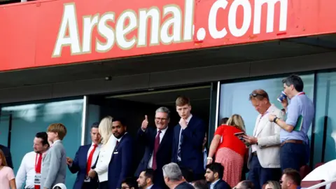 Reuters Kier Starmer with other football fans watching a match at Arsenal