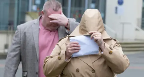 GARETH EVERETT/HUW EVANS AGENCY the couple hiding their faces outside court