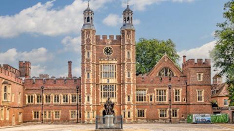 The main courtyard on the campus of Eton College red brick facade with cream inlays to windows and a statue centre