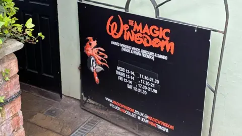 The sign outside the Magic Wingdom restaurant in Leamington with it's famous disney-style font writing.