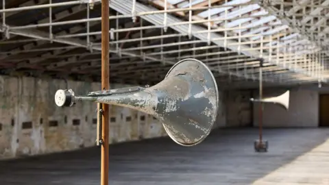 Bradford 2025 Old fashioned speakers on a pole in an empty mill space