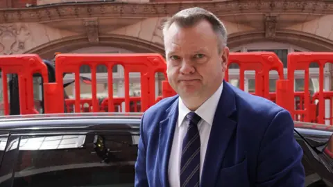 Cabinet Office minister Nick Thomas-Symonds arrives at the Infected Blood Inquiry in London, which is hearing evidence on the adequacy of the government's response to compensation, wearing a navy blue suit and tie