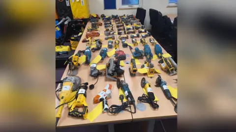 A large number of tools laid out on a table