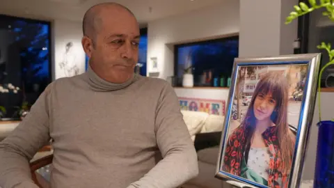 Mario Janin, Mia's dad, looks at an image of his daughter