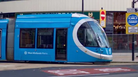 A blue tram featuring the West Midlands Metro logo on its side 